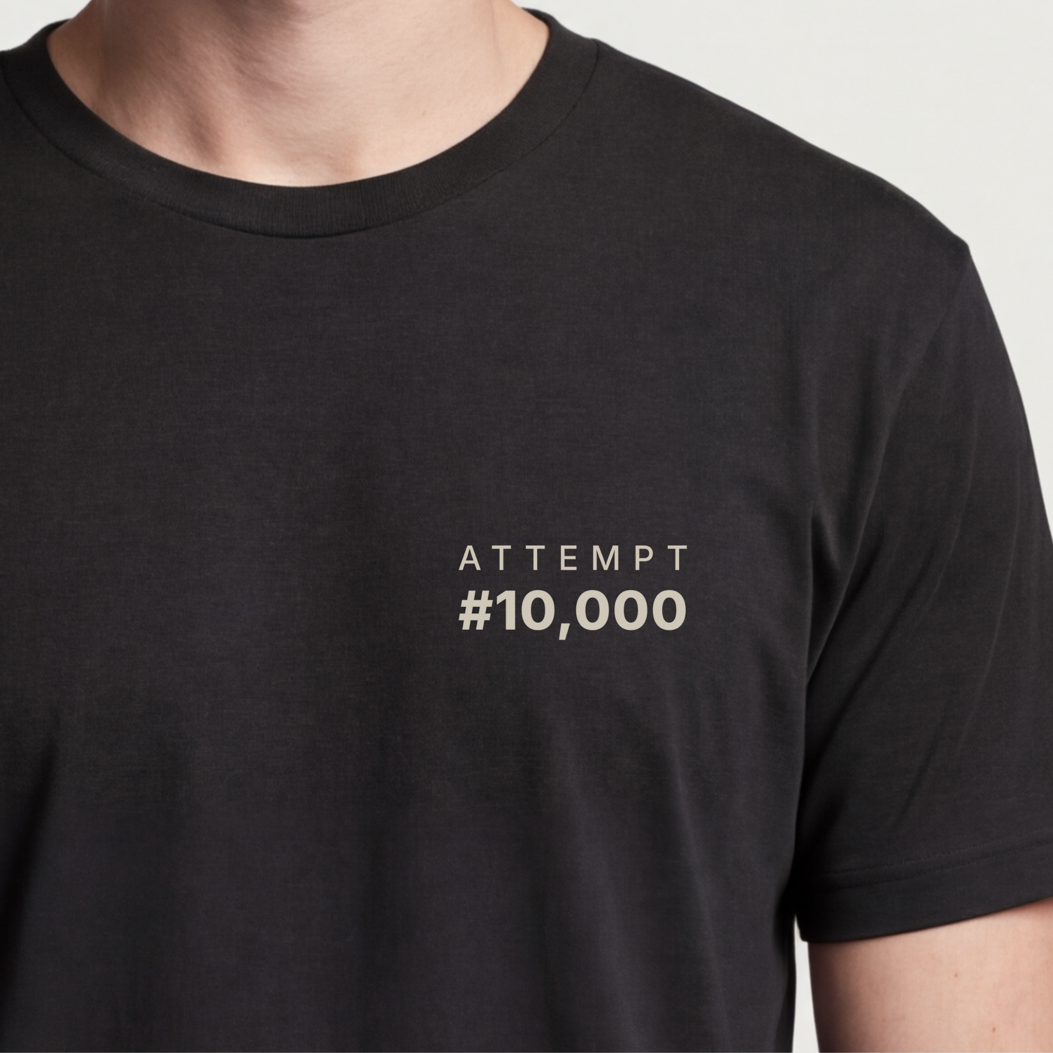 Founder Threads | Attempt #10,000 Tee. System Black grit and resilience gear for tech founders. Hero crop close-up.