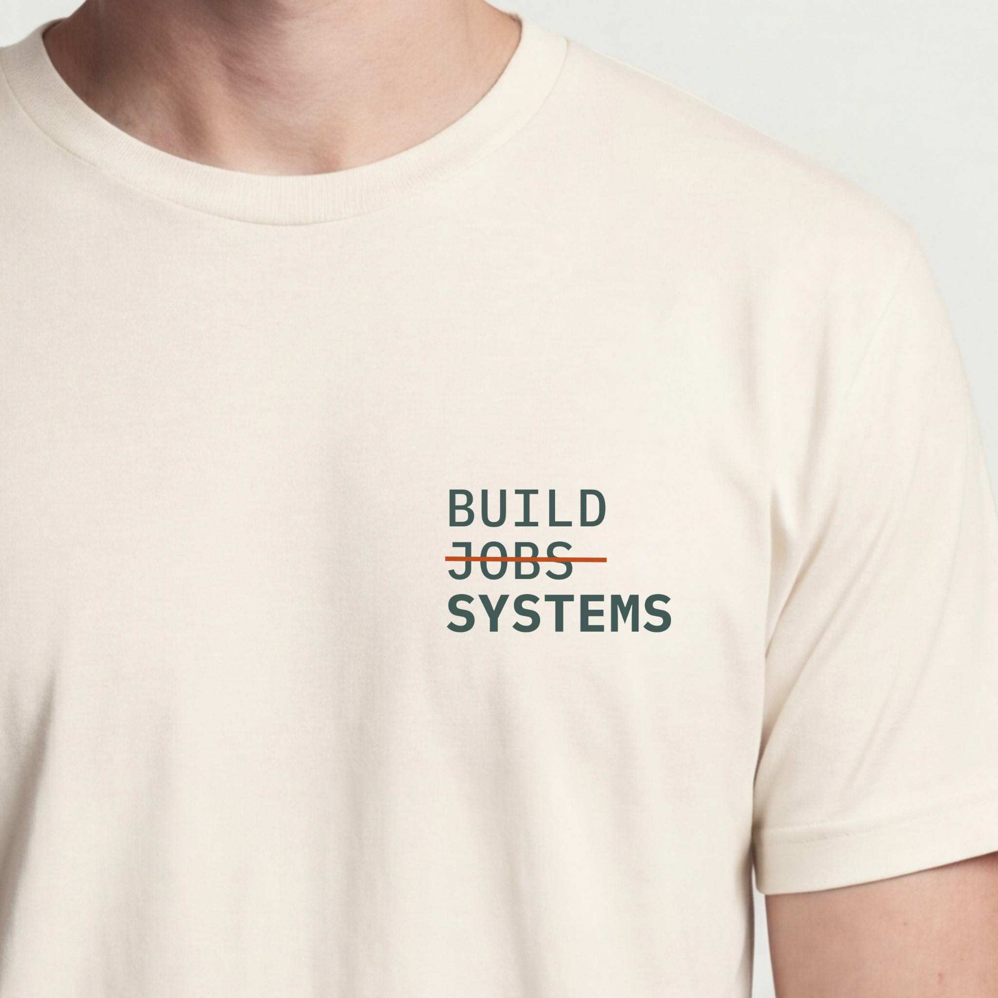 Founder Threads | Build Systems Not Jobs Technical Tee - Natural Bone - Hero Crop. Minimalist typography for engineers and founders.