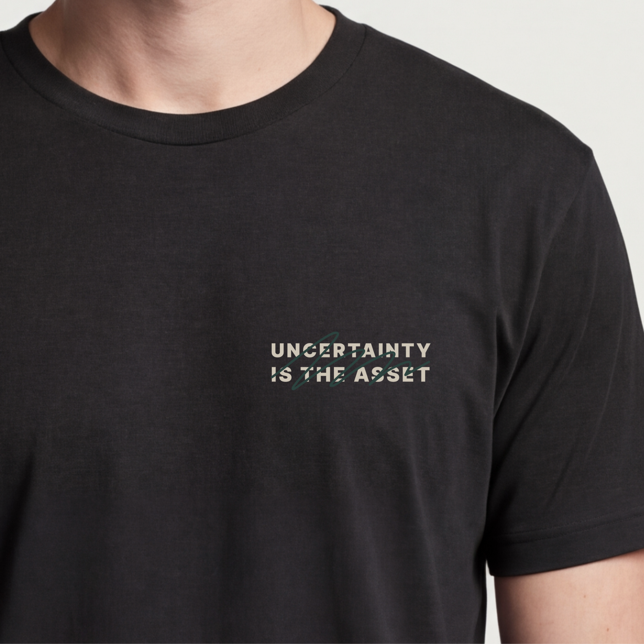 Founder Threads | Uncertainty Is The Asset Tee - System Black - Hero Crop. Gift for contrarian founders and risk-takers.